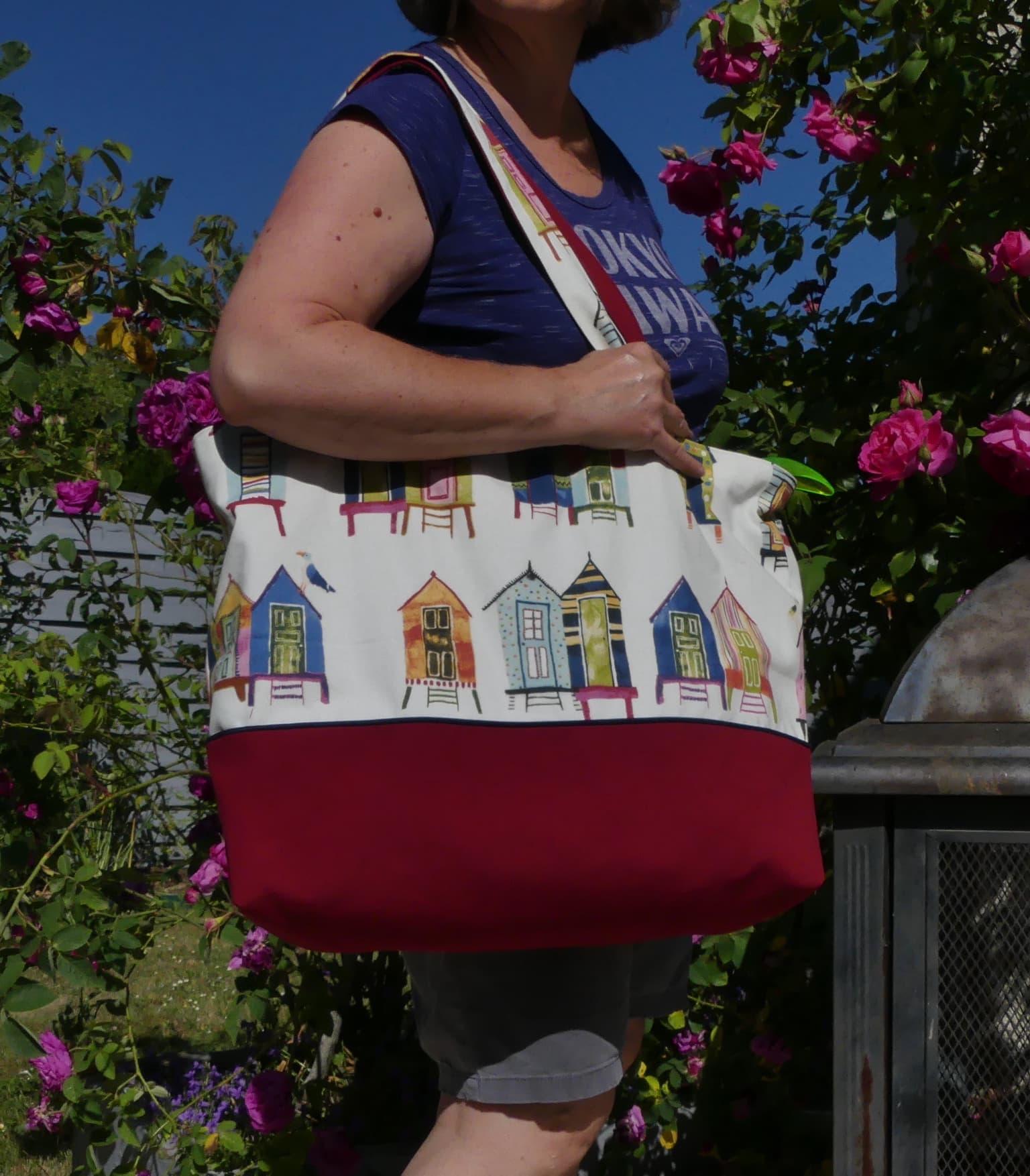 un sac de plage rouge et blanc avec des motifs de maisons de plage